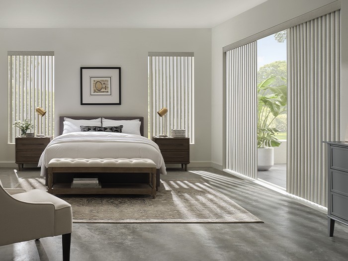 Bedroom with sliding glass doors featuring Cadence® Soft Vertical Blinds in Astor  Color: Silver Dew